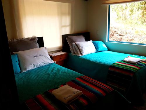 a room with two beds and a window at Cabañas Yukatan Lago de Tota in Tota