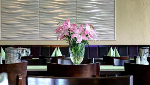 a vase of pink flowers sitting on a table at Hotel Restaurant Moselblick in Wintrich