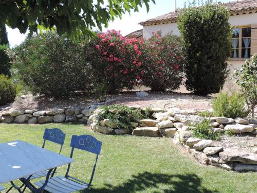 a picnic table and two chairs in a garden at Le faré tchanqué chambre d'hôtes, parking gratuit sur place in Cavaillon