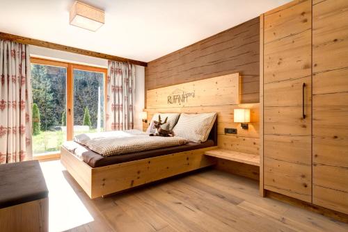 a bedroom with a bed with a wooden wall at Rufana Lodge in Bürserberg