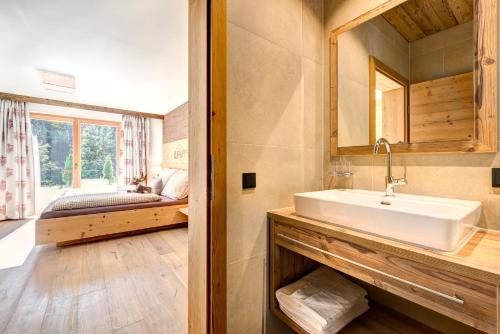 a bathroom with a sink and a bed in a room at Rufana Lodge in Bürserberg