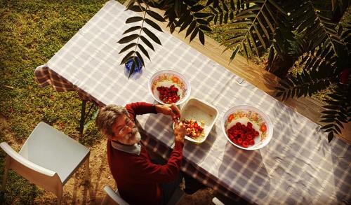 an older woman eating food at a picnic table at Bricco Del Gallo in Sinio