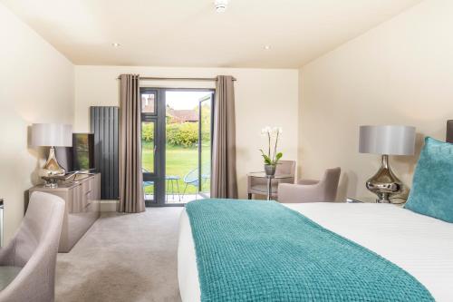 a bedroom with a bed and a sliding glass door at The Chequers Inn in Beaconsfield