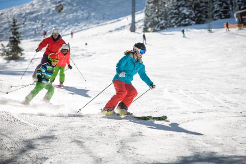a group of people skiing down a snow covered slope at Rufana Lodge in Bürserberg