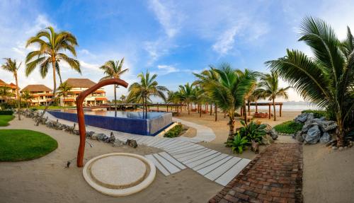 un complejo en la playa con palmeras en Las Palmas Luxury Villas, en Zihuatanejo