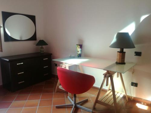 a room with a desk with a red chair and a mirror at Villa Grande in Messina
