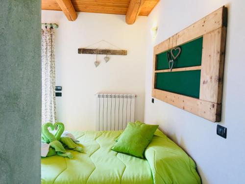 um quarto com uma cama verde num quarto em Bricco Del Gallo em Sinio