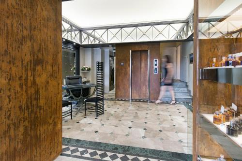 a person walking into a building with a lobby at Hotel Ancora in Verbania