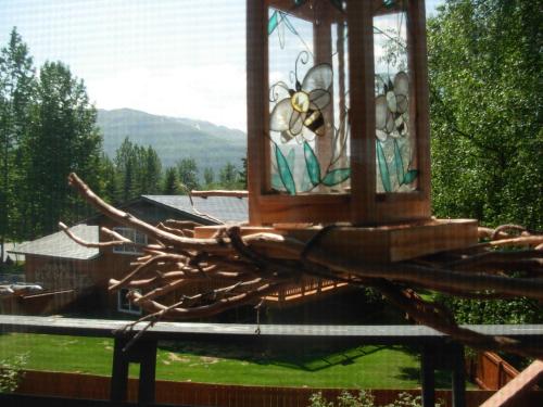 a bird feeder on top of a tree branch at Alaska Chalet Bed & Breakfast in Eagle River