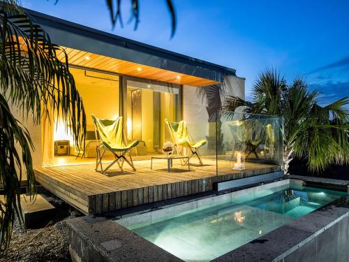 a house with a swimming pool and two lawn chairs at Donna Carmela Resort & Lodges in Riposto