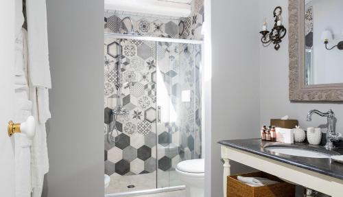 a bathroom with a shower with a toilet and a sink at Donna Carmela Resort & Lodges in Riposto