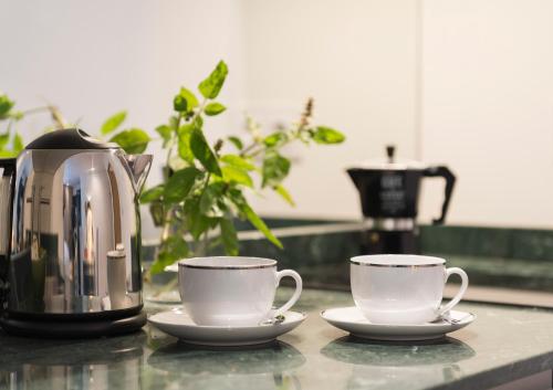 two coffee cups on a counter next to a tea kettle at Central - São Pedro Boutique in Funchal