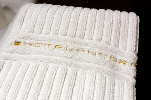 a white towel with the word retrieval written on it at Hotel Ancora in Verbania