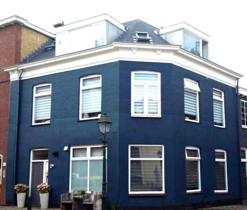a blue house with white windows and a street light at Bluebeach Scheveningen in Scheveningen