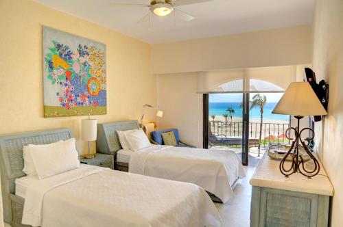 a bedroom with two beds and a view of the ocean at Condominios Brisa - Ocean Front in Cabo San Lucas