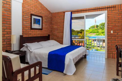 a bedroom with a bed and a balcony at Hotel & Resort Villa del Sol in Tumaco