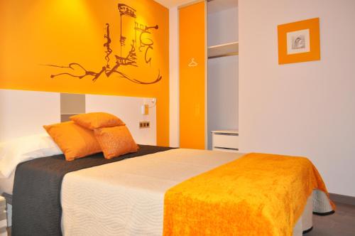 a bedroom with a bed with an orange wall at Rincón del Nazareno in Almazán