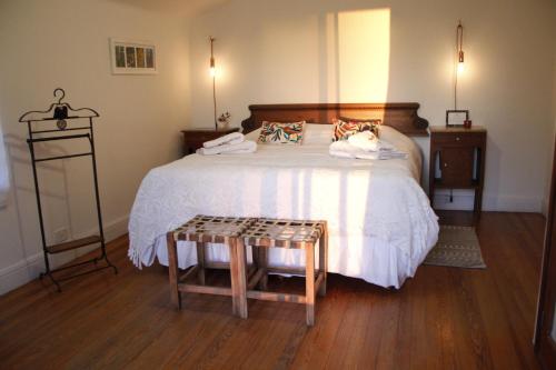 um quarto com uma cama grande e piso em madeira em Evergreen em La Cumbre