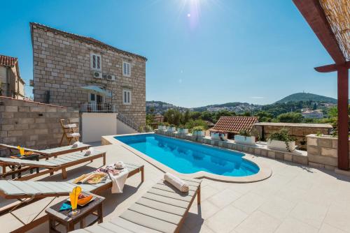 un cortile con piscina e mobili da giardino di Apartments Miljas 2 a Dubrovnik