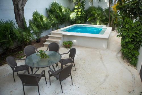 a patio with a table and chairs and a swimming pool at Cozy house downtown Cancun in Cancún