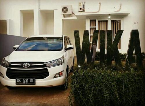 a white car parked in front of a building at Wika Bali Beach House in Jimbaran