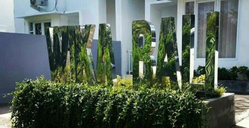 a building with a hedge in front of a building at Wika Bali Beach House in Jimbaran