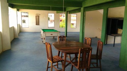 ein Zimmer mit einer Tischtennisplatte und Stühlen mit einem Billardtisch in der Unterkunft Hotel Vitalle in Juiz de Fora