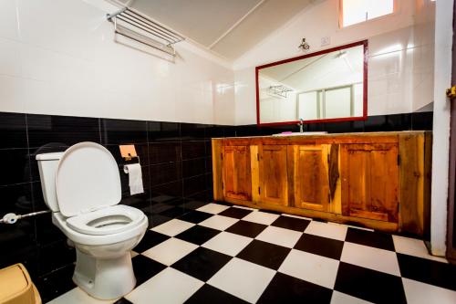 a bathroom with a toilet and a sink and a mirror at Dayanithi Guest House in Jaffna