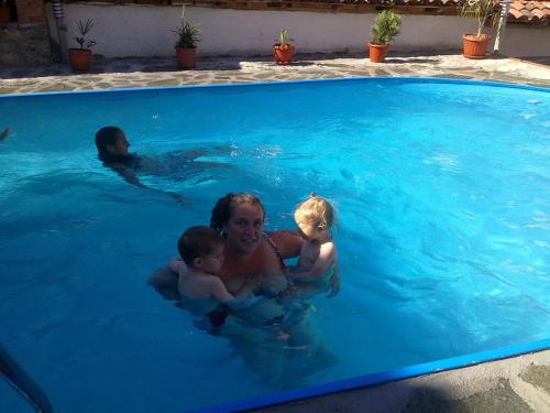 a woman and two children in a swimming pool at Guest House Todorini kashti in Koprivshtitsa