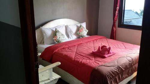 a pink stuffed animal sitting on top of a bed at Kohkaew Village 2@Kohsamet in Ko Samed