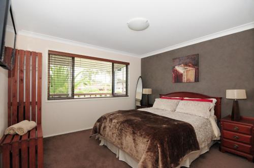a bedroom with a large bed and a window at Sandy Feet Getaway in Sanctuary Point