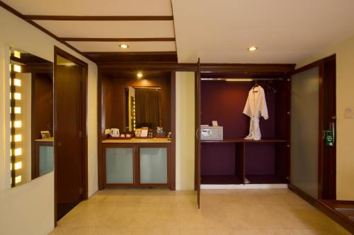 a hallway with a bathroom with a sink and a mirror at Hotel Atithi in Pondicherry