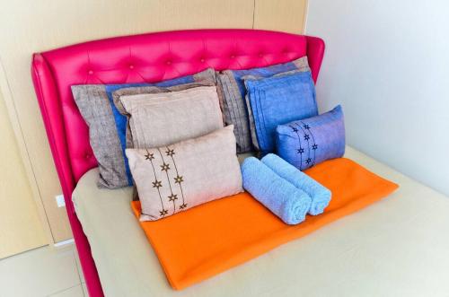un montón de mantas y almohadas sentadas en una cama en Son's Condo SMDC Wind Tagaytay en Tagaytay