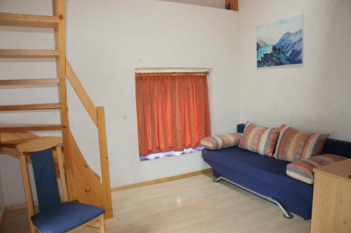 a living room with a blue couch and a staircase at Hotel Hof und Post in Innertkirchen