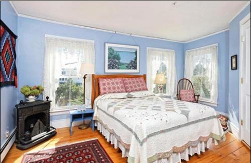 a blue bedroom with a large bed and a fireplace at Black Lantern B&B in Topsham