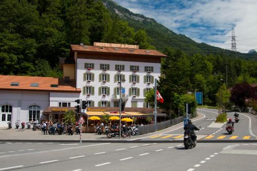 a man riding a motorcycle down a street in front of a building at Hotel Hof und Post in Innertkirchen