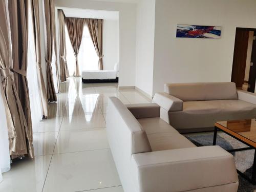 a white living room with a couch and chairs at KSL Hotel & Resort in Johor Bahru