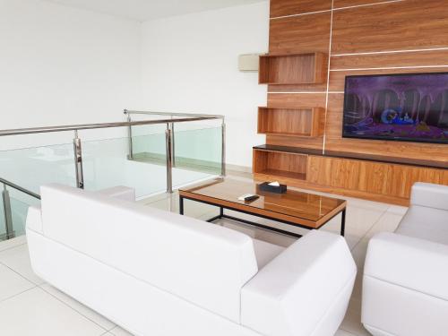a living room with two white couches and a tv at KSL Hotel & Resort in Johor Bahru