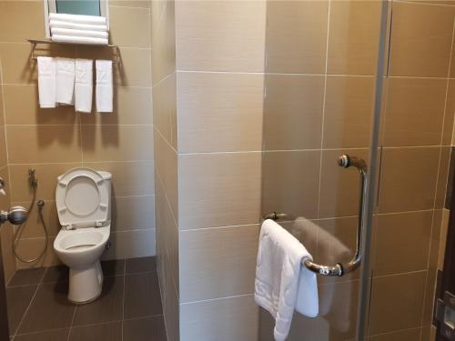 a small bathroom with a toilet and towels at KSL Hotel & Resort in Johor Bahru
