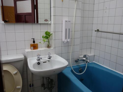 a bathroom with a sink and a bath tub at 拉瓦宅 輕旅店 - Lawa House #僅接待18-40歲青年旅人#Only for aged 18-40 in Chiayi City