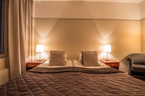 a hotel room with a bed and two lamps at Haparanda Stadshotell in Haparanda