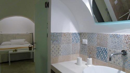 a bathroom with a sink and a bedroom with a bed at IL Quieto Uliveto in Ostuni
