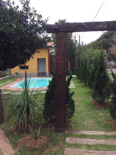 a wooden pole in a yard with a pool at Pousada Chalé na Roça Penedo in Penedo