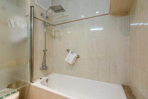 a bathroom with a bath tub and a toilet at Hotel Playa in Peñíscola