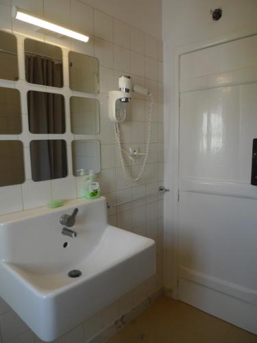 a bathroom with a white sink and a shower at ribeira dos marinheiros vermelho in Sintra