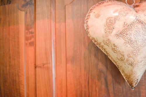 a copper heart hanging on a wooden wall at Hotel Landhaus Säntis Herisau in Herisau