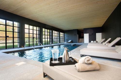 a swimming pool in a house with a table and towels at Réva Resort in Monforte dʼAlba