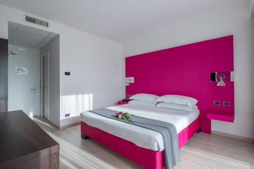 a large bed with a pink headboard in a room at Hotel Brandoli in Verona