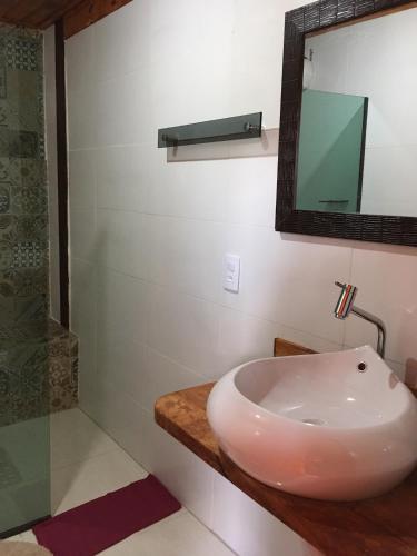 a bathroom with a sink and a mirror at Pousada Chalé na Roça Penedo in Penedo