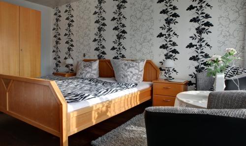a bedroom with a bed with a black and white patterned wall at Hotel Restaurant Moselblick in Wintrich